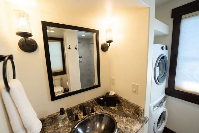 The main floor bathroom has a custom tile shower and access to the home`s laundry machines | Main Level